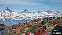 FILE PHOTO: Snow covered mountains rise above the harbor and town of Tasiilaq, Greenland, June 15, 2018. 