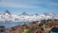 FILE - Snow-covered mountains rise above the harbor and town of Tasiilaq, Greenland, June 15, 2018. 