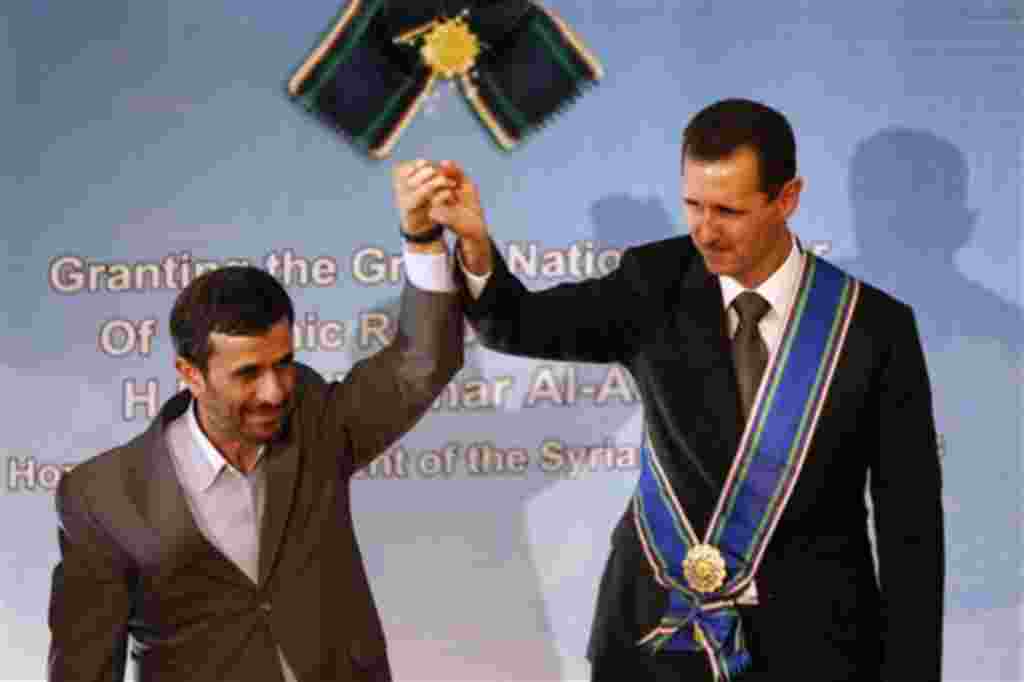 FILE - In this Oct. 2, 2010 file photo, Iranian President Mahmoud Ahmadinejad, left, holds up the hand of his Syrian counterpart Bashar Assad after he awarded Iran's highest national medal to Assad, in a ceremony in Tehran, Iran. When Syria's president la