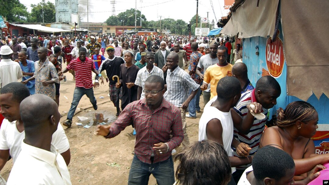 A September 28, 2009 photo shows Guinean demonstrators fleeing as security forces disperse them from outside the stadium where tens of thousands gathered for a pro-democracy rally, in Conakry. Security forces loyal to the ruling military junta opened fire on the crowd that day, killing at least 157 and raping dozens of women. 