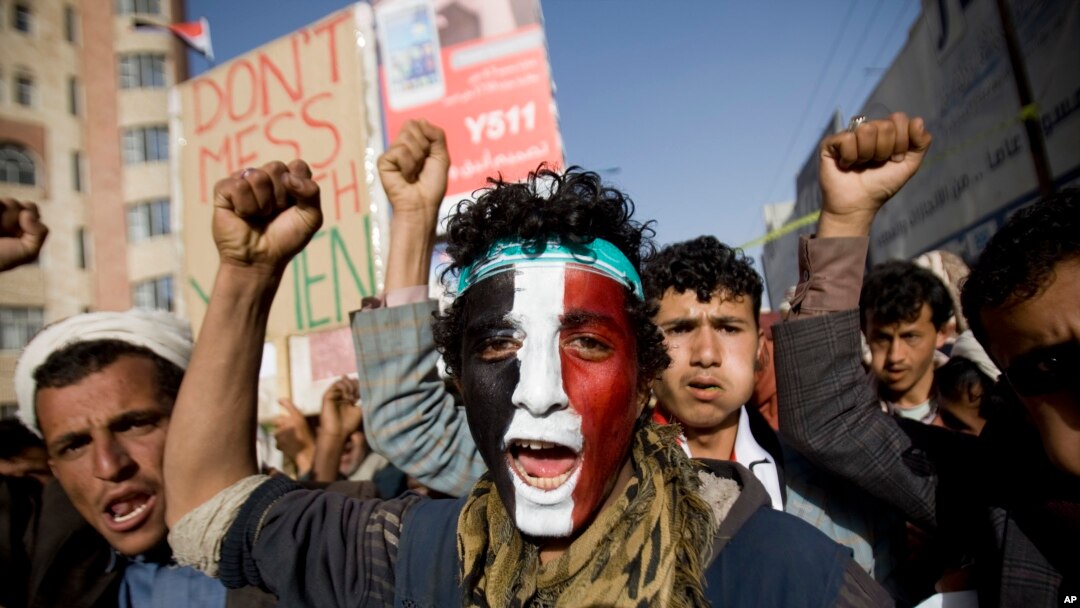 Seorang pemberontak Syiah Houthi dengan lukisan bendera Yaman di wajahnya meneriakkan slogan-slogan dalam protes di Sana'a, 27 Februari 2015. (AP/Hani Mohammed)