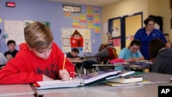 FILE - Seventh-grade students
attend English class in Newcastle, Oklahoma on March 30, 2017. The latest test scores show that American 13-year-old students are back to their lowest level in math since 1990 and lowest reading level since 2004. (AP Photo/Sue Ogrocki)