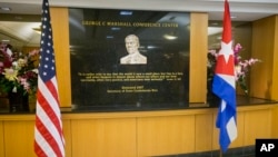 FILE - U.S. and Cuban flags are seen displayed at the George C. Marshall Conference Center at the State Department in Washington, Feb. 27, 2015. 