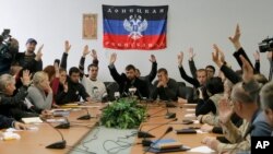 Anggota pemerintahan "Republik Donetsk" yang diproklamirkan sendiri oleh para anggotanya memberikan suaranya dalam pertemuan di gedung pemerintahan yang mereka duduki di Donetsk, Ukraina (10/4). 