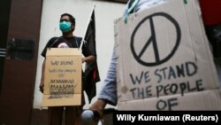 Demonstran membawa plakat saat melakukan protes terhadap kudeta militer di Myanmar, di luar Kedutaan Besar Myanmar di Jakarta, 5 Februari 2021. (Foto: REUTERS/Willy Kurniawan)