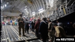 Afghans board a U.S. Air Force C-17 Globemaster III transport plane during an evacuation at Hamid Karzai International Airport, Afghanistan, August 22, 2021. (U.S. Air Force/Handout via Reuters)