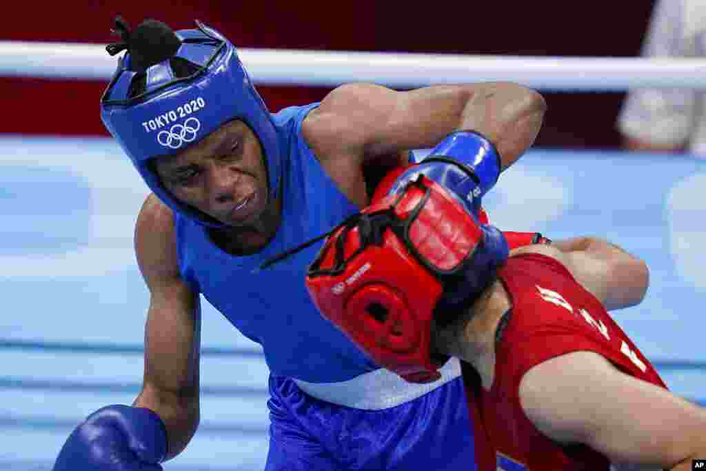 Uzbekistan&#39;s Raykhona Kodirova, right, exchanges punches with Naomie Yumba, of the Democratic Republic of the Congo, during their women&#39;s lightweight 60-kg boxing match at the 2020 Summer Olympics, Friday, July 30, 2021, in Tokyo, Japan. (AP Photo/Frank Franklin II)