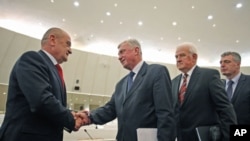 Bosnia's new Prime Minister Vjekoslav Bevanda (L) receives congratulations from members of parliament, in Sarajevo, January 12, 2012.