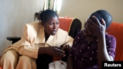 FILE - Apollonie, a Congolese counselor, speaks with a rape victim in the HEAL Africa hospital in Goma.