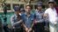 Police officers accompany Nyi Nyi Lwin, second from left, also known as Shin Gambira, a former Buddhist monk and a leader of the 2007- Saffron Revolution, to a courthouse in Mandalay, Myanmar, Feb. 16, 2016.