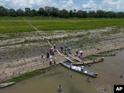 FILE - People from the Tikuna Indigenous receive aid from an NGO because of the drought along the Amazon River in Santa Sofia, on the outskirts of Leticia, Colombia, Sunday, Oct. 20, 2024. (AP Photo/Ivan Valencia)