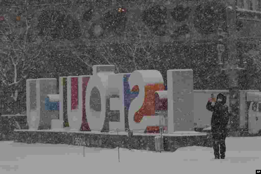 مردی در سرما، کنار نمادی در شهر سئول پایتخت کره جنوبی عکس می‌گیرد. 