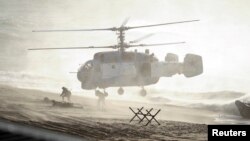 FILE - Servicemen take part in the joint war games Zapad-2013 (West-2013), at the Khmelevka range on Russia's Baltic Sea in the Kaliningrad Region, Sept. 26, 2013. 