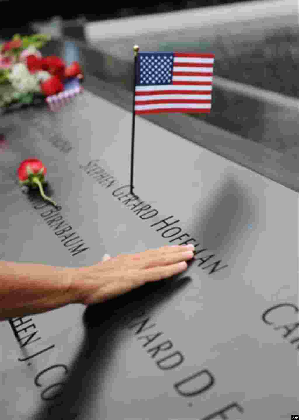 A mourner traces the name of a victim of the Sept. 11 terrorist attacks during a ceremony marking the 10th anniversary of the attacks Sunday, Sept. 11, 2011 at the National September 11 Memorial at the World Trade Center site in New York. (AP Photo/David 