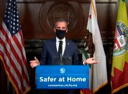 Walikota Eric Garcetti mengenakan masker pelindung wajah selama konferensi pers hariannya di Los Angeles pada hari Rabu, 1 April 2020. (Foto: AP)