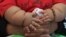 FILE - An eight-month-old boy is held by his mother as they wait to see a doctor at a clinic for the obese in Bogota, March 19, 2014.