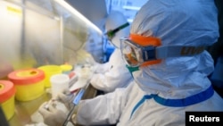 Los trabajadores en trajes de protección realizan pruebas de ARN en muestras dentro de un laboratorio en un centro de control y prevención de enfermedades, ya que el país se ve afectado por un brote del nuevo coronavirus, en Taiyuan, provincia de Shanxi, China.