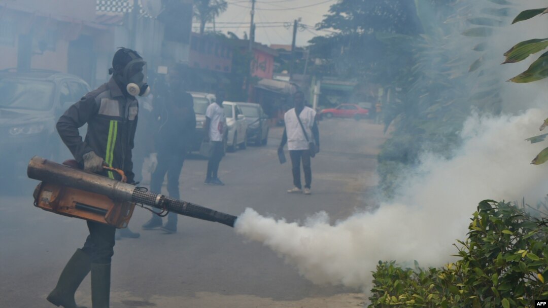 FILE - Officers of the National Institute for Public Hygiene (INHP) fumigate an area to prevent mosquitoes from breeding as part of a campaign against mosquito-borne viruses, in Abidjan, June 3, 2019.