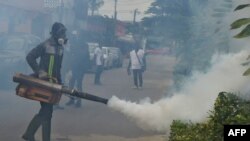 FILE - Officers of the National Institute for Public Hygiene (INHP) fumigate an area to prevent mosquitoes from breeding as part of a campaign against mosquito-borne viruses, in Abidjan, June 3, 2019.