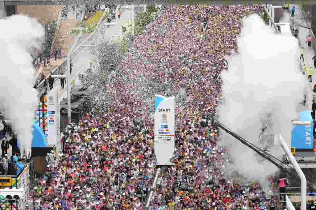 Runners start the Tokyo Marathon as they pass the Tokyo Metropolitan Government Building in Tokyo, Japan.