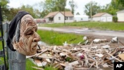 A mask hangs on a fence overlooking debris from a flood-damaged home in Pacific Junction, Ia., May 24, 2019. Rep. Chip Roy, R-Texas, has blocked a $19 billion disaster aid bill that would deliver money to states hit by hurricanes, floods and fires.