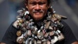 A protester wears a chain with many amulets as he joins others in a march towards central Bangkok, Thailand. Thousands of people took to the streets of the Thai capital after lawmakers approved a draft political amnesty bill that could allow the return of self-exiled former premier Thaksin Shinawatra.