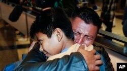 David Xol-Cholom, of Guatemala hugs his son Byron at Los Angeles International Airport as they reunite after being separated about one and half year ago during the Trump administration's wide-scale separation of immigrant families, Jan. 22, 2020.