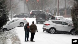  Motorists talk outside their cars after being involved in several accidents because of icy roads, Jan. 6, 2017, in Nashville, Tenn. Winter weather closed schools and made driving conditions hazardous.