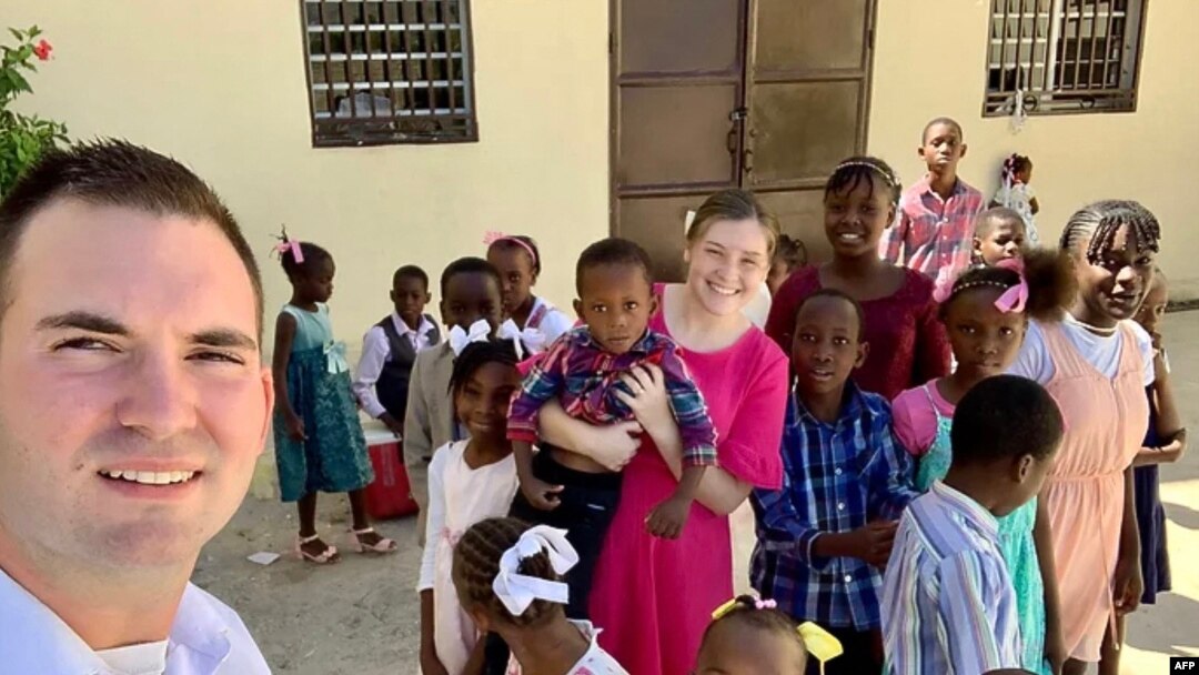 In this undated photo courtesy of Missions in Haiti, U.S. missionaries Davy and Natalie Lloyd pose with Haitian children. Gang members killed the couple in Port-au-Prince on May 23, 2024.