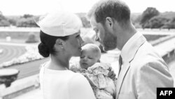 Pangeran Harry yang bergelar Duke of Sussex (kanan) dan istrinya, Meghan, Duchess of Sussex memeluk bayi laki-laki mereka, Archie Harrison Mountbatten-Windsor di Kastil Windsor dalam foto resmi upacara pembaptisan Archie, Sabtu, 6 Juli 2019. (Foto: Chris 