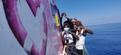 Orang-orang setelah diselamatkan oleh Louise Michel, kapal pencari dan penyelamat migran yang beroperasi di Mediterania dan dibiayai oleh seniman jalanan Inggris Banksy, di laut. (MV Louise Michel via Reuters)