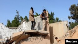 Members of the Libyan internationally recognised government forces look out from a destroyed building at Khallat Farjan area in Tripoli, Libya, Apr. 20, 2019. 