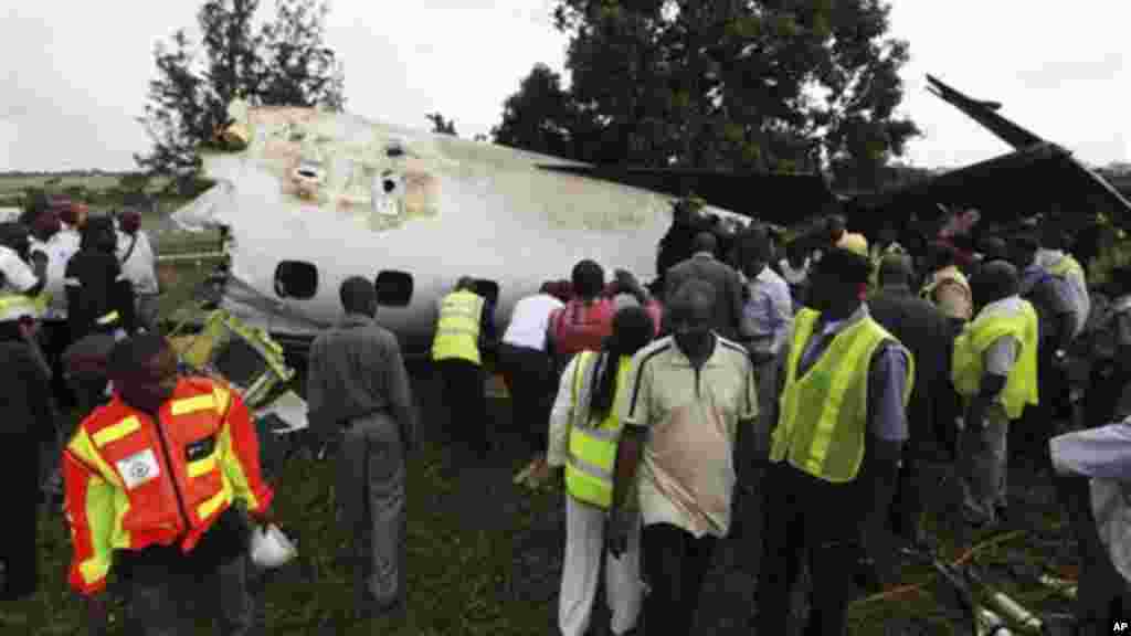 Rescue workers gather around the wreckage of a charter passenger jet which crashed soon after take off from Lagos airport.