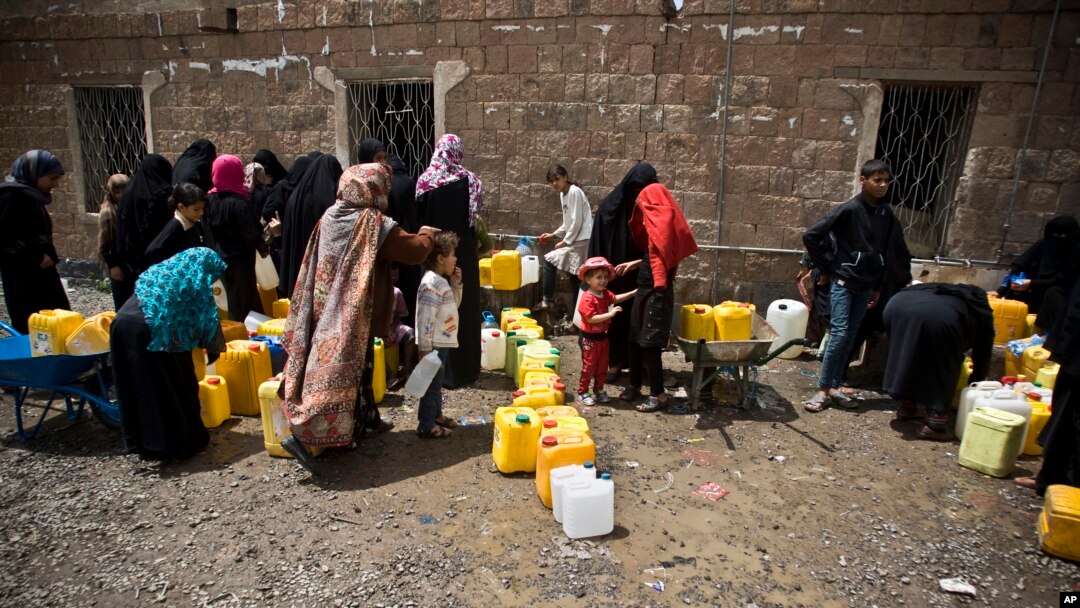 FILE - Women and children wait to fill buckets with water from a public tap amid an acute shortage of water, in Sana'a, Yemen, May 9, 2015. 
