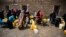 FILE - Women and children wait to fill buckets with water from a public tap amid an acute shortage of water, in Sana'a, Yemen, May 9, 2015. 