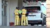 Employees block the media as Dr. Peter Magombeyi, of the Zimbabwe Hospital Doctors Association, is transported to the airport to fly to South Africa for what his medical team calls "urgent" treatment, in Harare, Sept. 26, 2019. (C. Mavhunga/VOA)