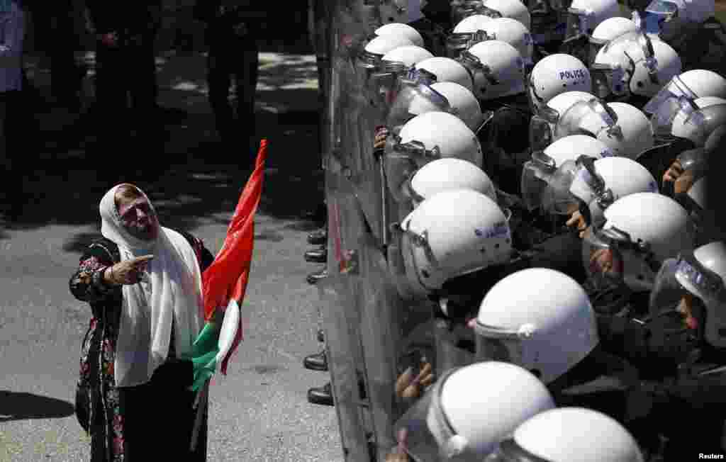 A Palestinian protester gestures in front of riot police during a demonstration against renewed peace talks between Israelis and Palestinians, in the West Bank city of Ramallah.