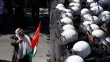 A Palestinian protester gestures in front of riot police during a demonstration against renewed peace talks between Israelis and Palestinians, in the West Bank city of Ramallah.