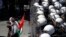 A Palestinian protester gestures in front of riot police during a demonstration against renewed peace talks between Israelis and Palestinians, in the West Bank city of Ramallah.