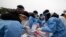 Medical workers wearing protective gear prepare to take samples at a temporary screening clinic for coronavirus in Seoul, South Korea, Dec. 10, 2021.