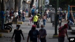 Ciudadanos caminan por una calle en el barrio Catia de Caracas, Venezuela. Abril 7, 2021.