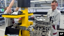 FILE - Workers complete a new diesel engine at the MDC Power GmbH, a company of the German Daimler AG, in Koelleda, Germany, Oct. 23, 2015.