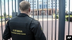 FILE - A guard stands behind a fence at the main entrance of the Moscow Regional Court, in Moscow, Russia, Aug. 1, 2017.