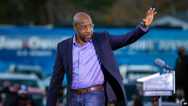 ARCHIVO - El candidato demócrata al Senado de los Estados Unidos, el reverendo Raphael Warnock, saluda a sus partidarios durante un autocine, el 3 de enero de 2021, en Savannah, Georgia.