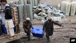 Afghan workers of the election commission office unload a ballot box from a truck after votes in Jalalabad, east of Kabul, Afghanistan, Sunday, April 6, 2014.