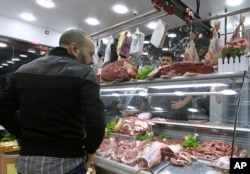 FILE — People shop for beef at a butchery in Algiers, Algeria, February18, 2024.