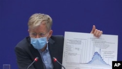 Bruce Aylward, an assistant director-general of the World Health Organization speaks with a chart during a press conference in Beijing on Monday, Feb. 24, 2020.
