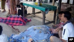 Buddhist villagers mourn next to the bodies of their slain relatives in Pattani province, southern Thailand, February 3, 2011.