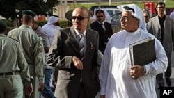 Bahraini lawyer Mohamed al-Tajer, right in white, walks away from the Manama, Bahrain, courthouse where the first session of a heavily guarded trial opened for more than two dozen Shiite activists accused of plotting against Bahrain's Sunni rulers. The de