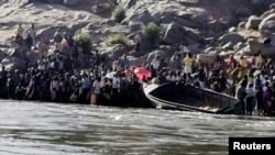Ethiopians who fled the ongoing fighting in Tigray region prepare to cross the Setit River on the Sudan-Ethiopia border in Hamdait village in eastern Kassala state, Sudan, Nov. 14, 2020. 
